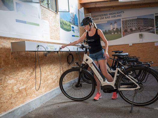 Radfahrerin läd das gemietete E-Bike im Radverleih Bad Aibling auf